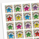A sheet of square holographic 'Superstar' stickers featuring alternating assorted coloured cartoon stars wearing sunglasses. Each star has the word 'SUPERSTAR' in a curved black font above it, set against a sparkly silver background.