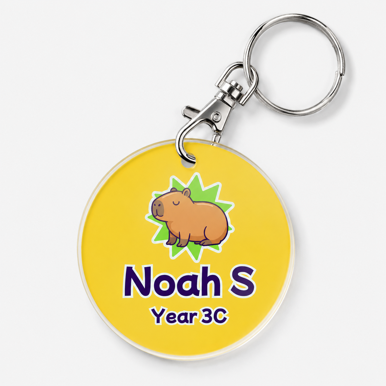 A personalized acrylic bag tag featuring a capybara and example text 'Noah S Year 3C'. 