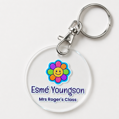 A personalized acrylic bag tag featuring a flower and example text 'Esme Youngson Mrs Roger's Class'. 