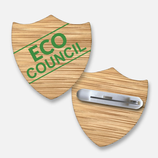 Shield-shaped 35mm bamboo badge with a natural wood grain finish, featuring the text 'ECO COUNCIL' in green, bold uppercase letters; includes a metal pin fastening on the reverse, ideal for recognising pupils' contributions to environmental initiatives.
