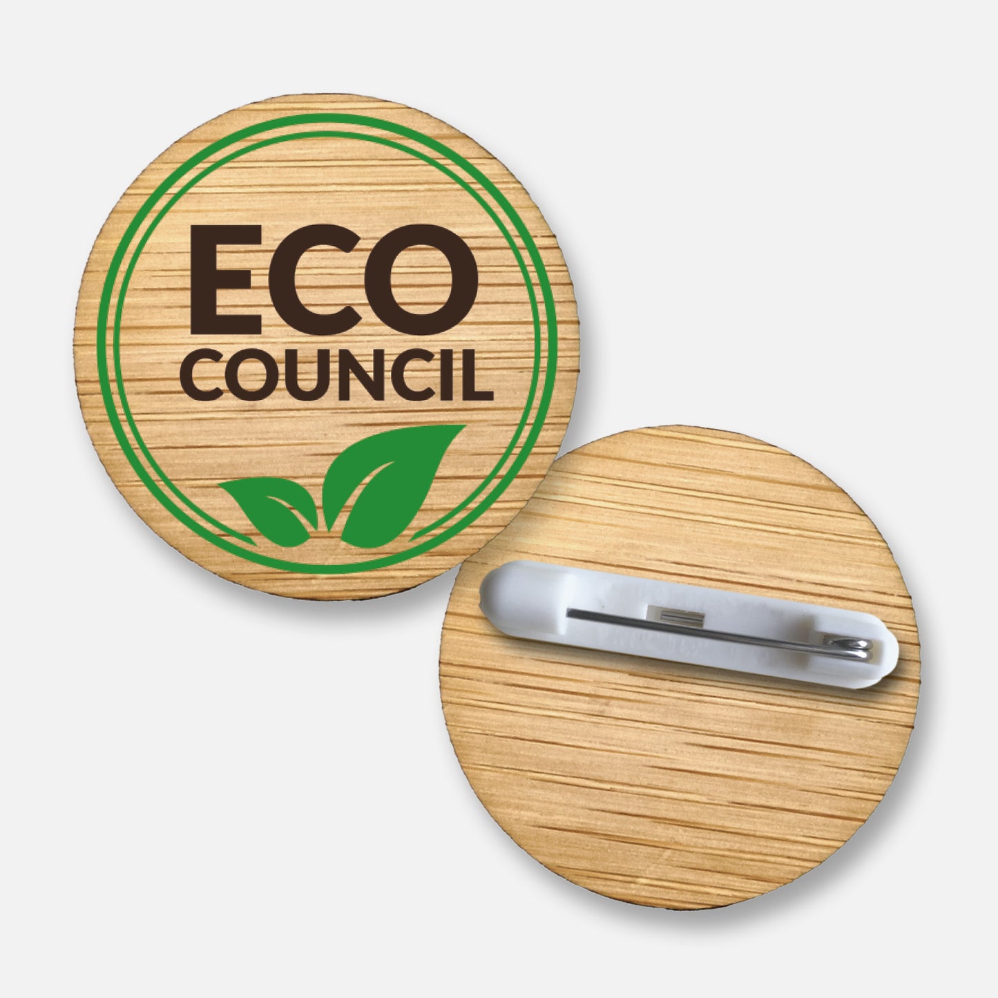 A 38mm circular badge crafted from natural bamboo, featuring the phrase 'ECO COUNCIL' in brown capital letters on the front, encircled by a green double line and green leaf.  Pin fastening on the reverse side.