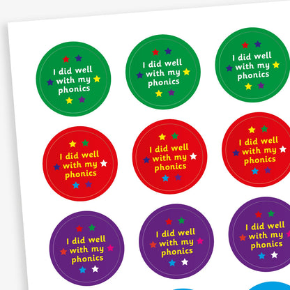 A sheet of colourful circular stickers featuring 'I did well with my phonics' on backgrounds including green, red, purple and cyan.