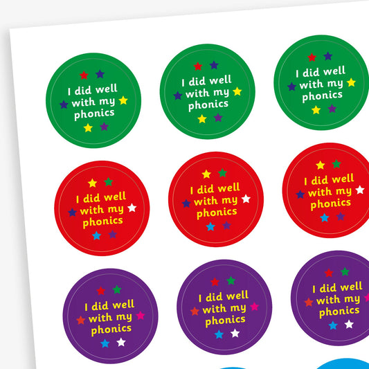 A sheet of colourful circular stickers featuring 'I did well with my phonics' on backgrounds including green, red, purple and cyan.