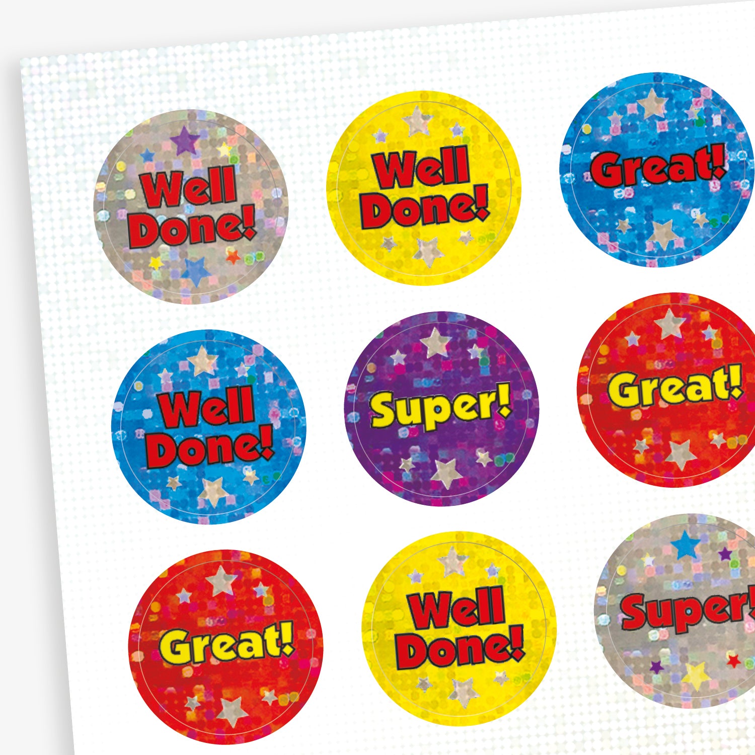 A sheet of colourful circular reward stickers with holographic star backgrounds. Each sticker features a positive message such as 'Well Done!', 'Great!', or 'Super!' in bold, vibrant text. Background colours include red, blue, yellow, purple, and silver.