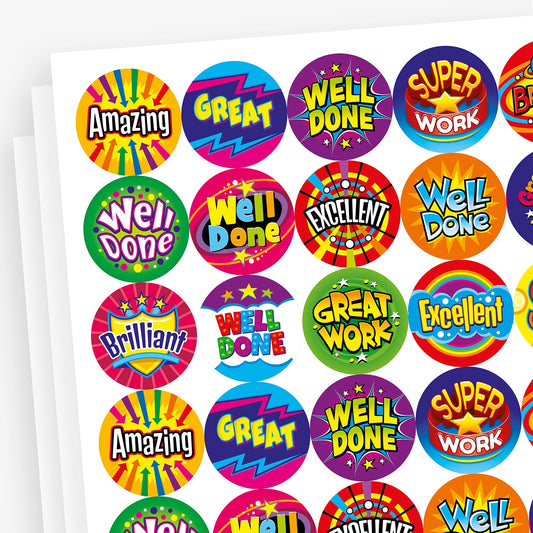 A sheet of berry scented, vibrant, circular reward stickers with bold, comic-style designs. Each sticker features a motivational phrase such as 'Amazing', 'Great', 'Well Done', 'Super Work', 'Brilliant', 'Excellent', and 'Great Work'. The backgrounds are colourful and eye-catching, using starbursts, lightning bolts, and bold typography to create an energetic and celebratory effect.