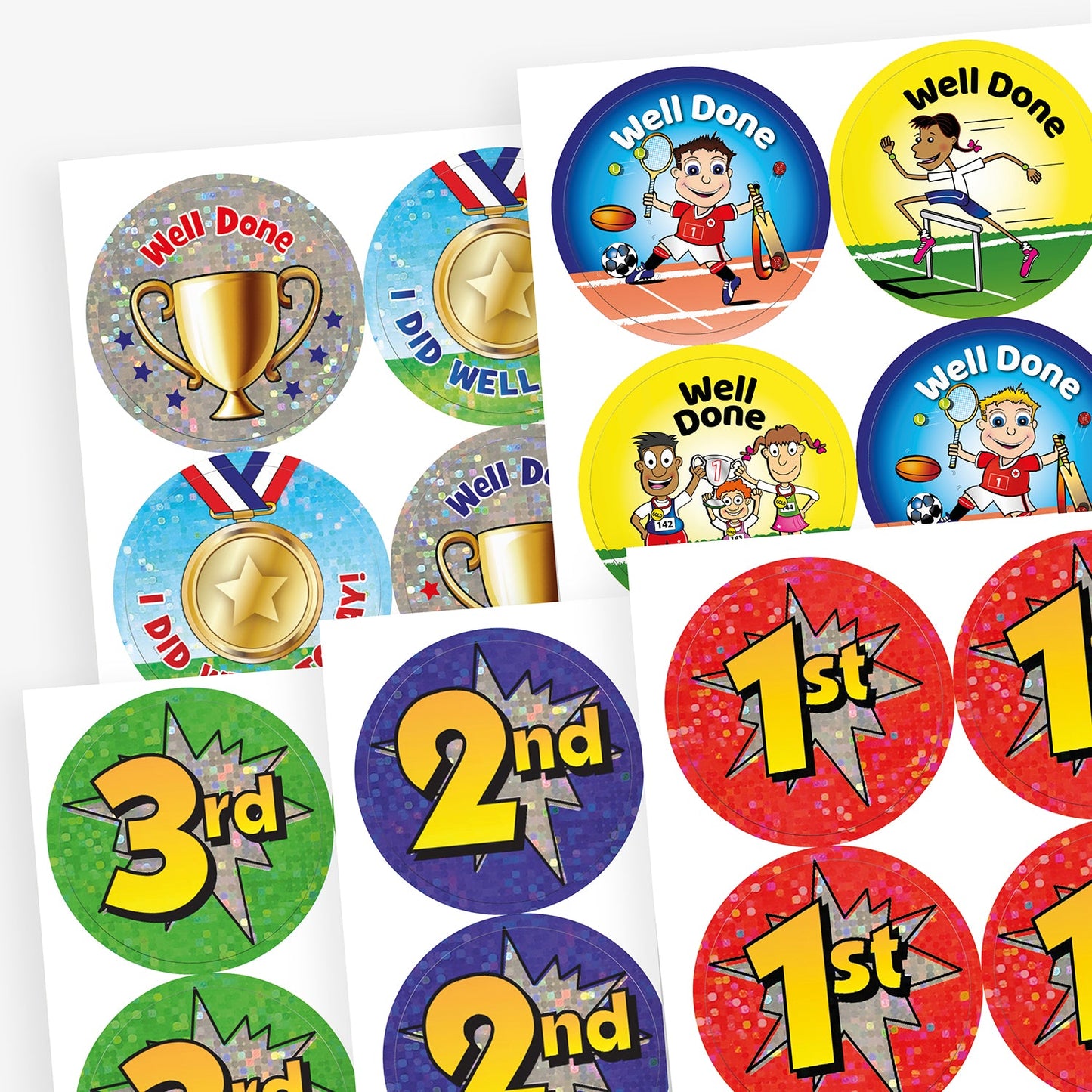 A selection of colourful reward and achievement stickers, including 'Well Done' stickers featuring children playing sports, stickers with gold trophies and medals, and large sparkly '1st', '2nd', and '3rd' place stickers in red, blue, and green. 