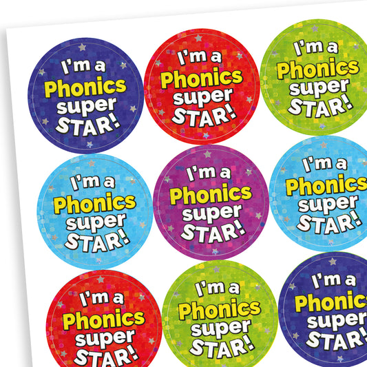 A sheet of circular holographic reward stickers with the text 'I'm a Phonics Super Star!' in bold, playful font. Each sticker has a colourful background in shades of blue, red, green, purple, and more, decorated with subtle stars.