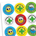 Sheet of vibrant coloured circular stickers with two main designs.  A cartoon face with a plaster or bandage on the head has text surrounding the image saying 'I bumped my head today!'; the seconf is a central first aid cross with the words 'I bumped my head today.  Please keep an eye on me' sorrounding it
