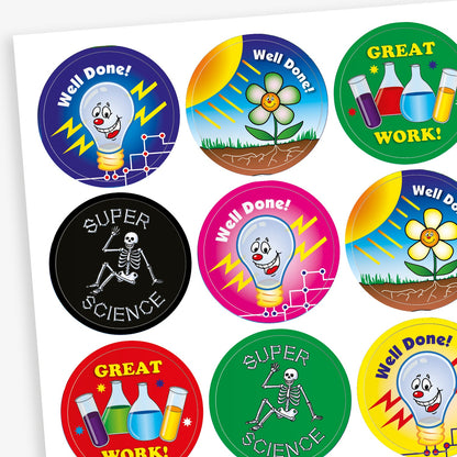 A sheet of colourful circular science-themed reward stickers. Designs include: a smiling lightbulb with 'Well Done!', a growing plant under the sun, test tubes and beakers with 'GREAT WORK!', a skeleton with 'SUPER SCIENCE', and various bright backgrounds in colours like blue, pink, red, green, and yellow.