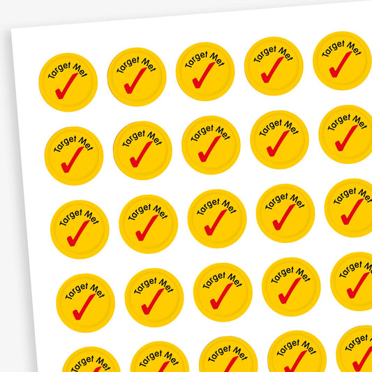 Sheet of 196 assorted 10mm circular reward stickers featuring large red tick icon on a yellow background, each sticker has the phrase 'Target Met' above the tick. Each sticker is designed to motivate and reward pupils, suitable for use on charts, books, and clothing.