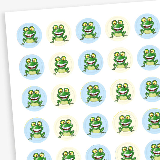 Sheet of 196 assorted 10mm circular reward stickers featuring a smiling cartoon frog, on a background of either light blue or cream. Each sticker is designed to motivate and reward pupils, suitable for use on charts, books, and clothing.