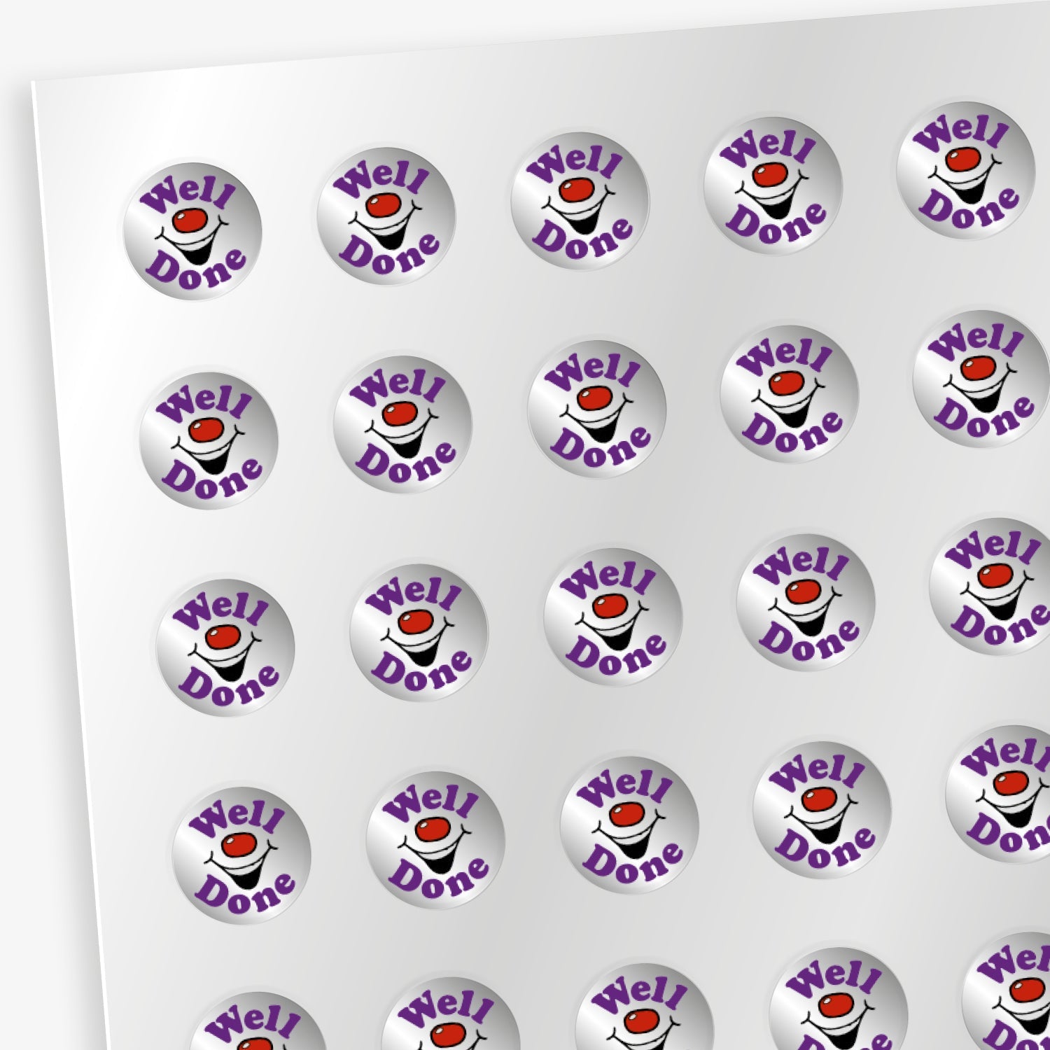 Sheet of 196 metallic 10mm circular silver reward stickers, each with a central red nose and smiling mouth with the word 'Well' in bold purple lettering above the image and 'Done' below the image. The stickers have a shiny, reflective finish and are designed to motivate and reward pupils' achievements.