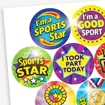 A sheet of holographic sports themed stickers with phrases such as 'I'm a SPORTS Star', 'I'm a GOOD SPORT', 'I TOOK PART TODAY' and 'Sports STAR' with a variety of backgrounds including stars, medals and rosettes.