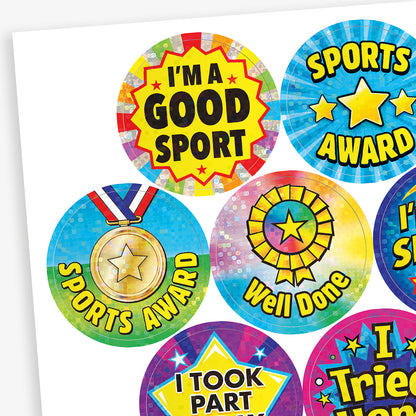 A sheet of holographic sports themed stickers with phrases such as 'I'm a SPORTS Star', 'I'm a GOOD SPORT', 'I TOOK PART TODAY' and 'Sports STAR' with a variety of backgrounds including stars, medals and rosettes.