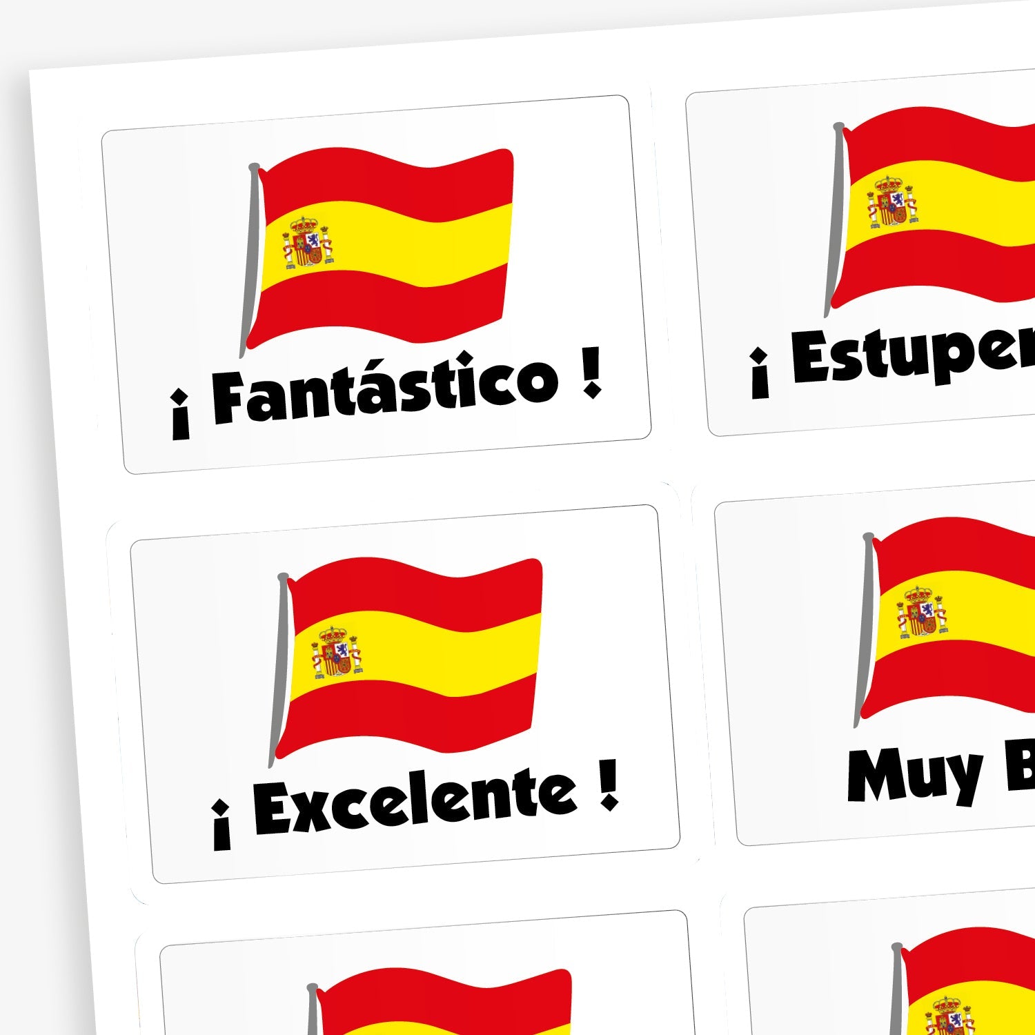 A sheet of white rectangular stickers featuring the Spanish flag and Spanish praise words. Phrases include '¡Estupendo!', '¡Excelente!', 'Muy bien', and 'Fantástico'. 