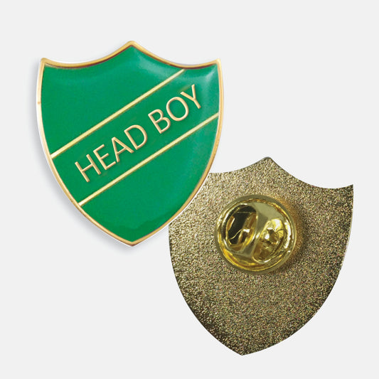 Green enamel badge in the shape of a shield with gold trim and diagonal gold line either side of the words 'HEAD BOY' in capital letters. The reverse side shows a textured gold back with a pin fastening