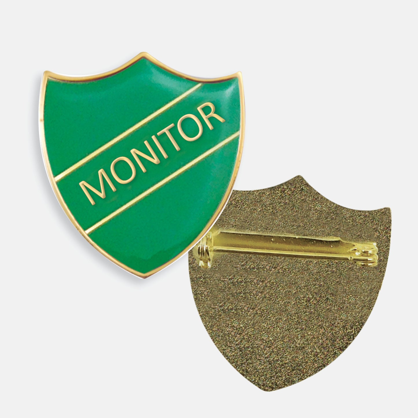 Green enamel badge in the shape of a shield with gold trim and diagonal gold line either side of the word 'MONITOR' in capital letters. The reverse side shows a textured gold back with a pin fastening