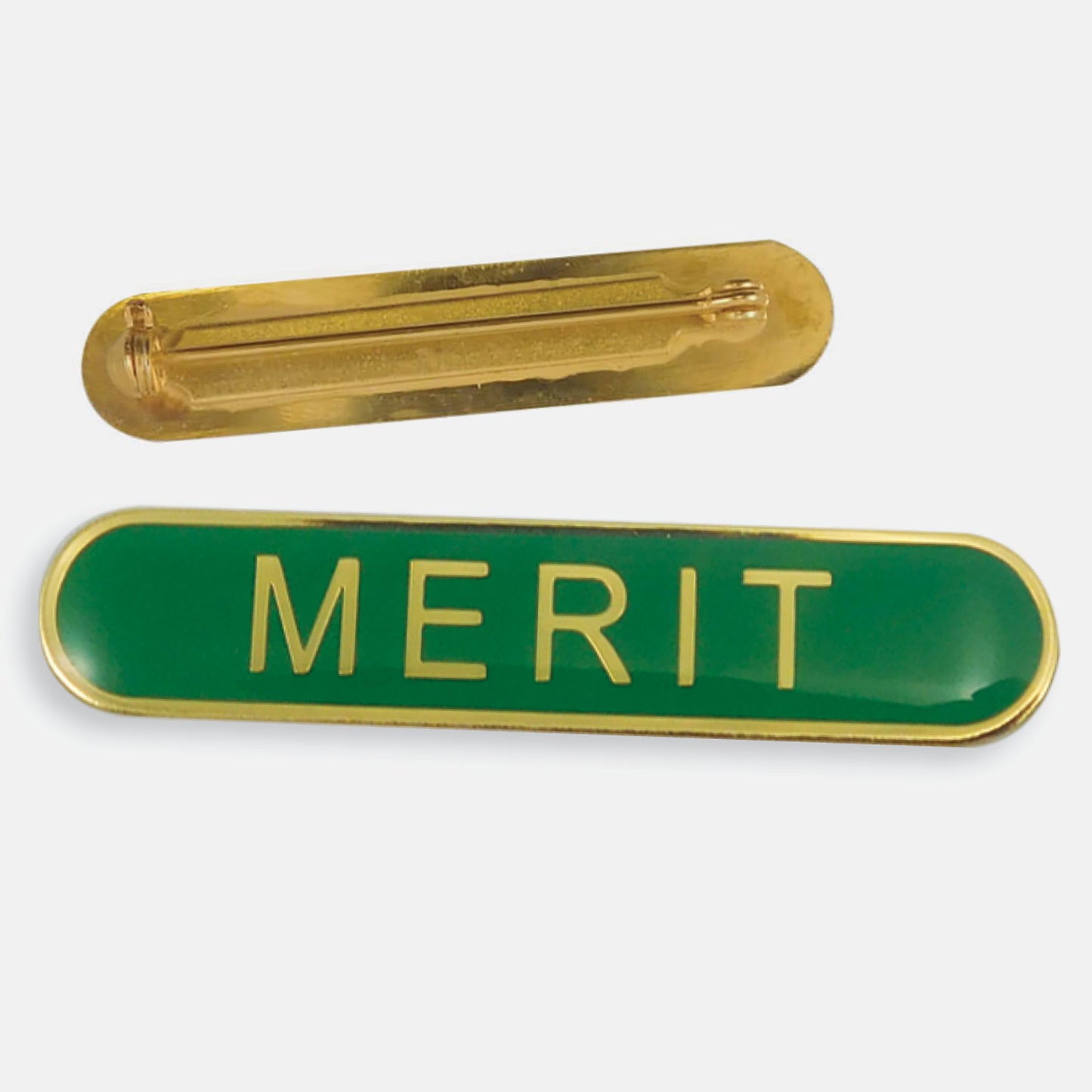 Green enamel badge in a long oval shape with a gold trim and the word 'MERIT' central in gold capital letters. The reverse side shows a gold back with a pin fastening
