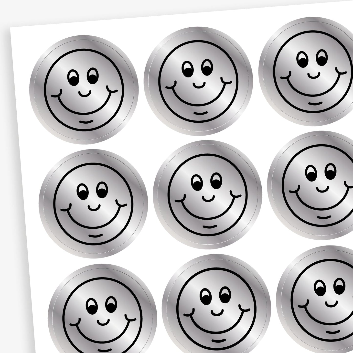A sheet of metallic silver stickers each with a smiling face as a black outline as it's design