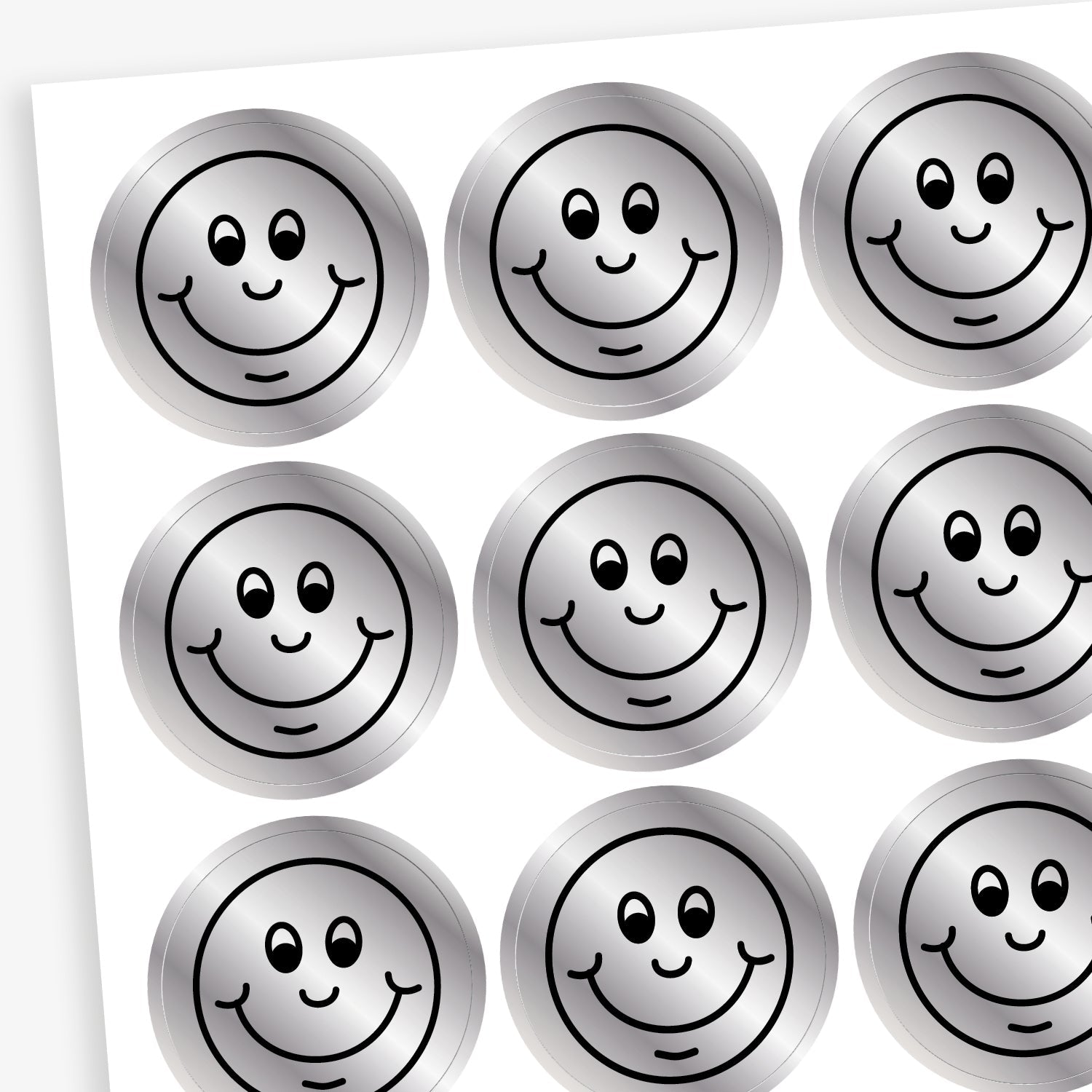A sheet of metallic silver stickers each with a smiling face as a black outline as it's design