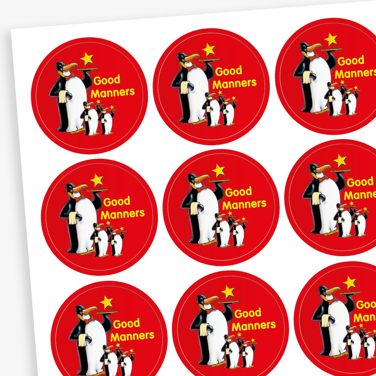 A sheet of red circular reward stickers for children. Each sticker features a group of three cartoon penguins standing together, with a yellow star above them and the phrase 'Good Manners' written in yellow text.