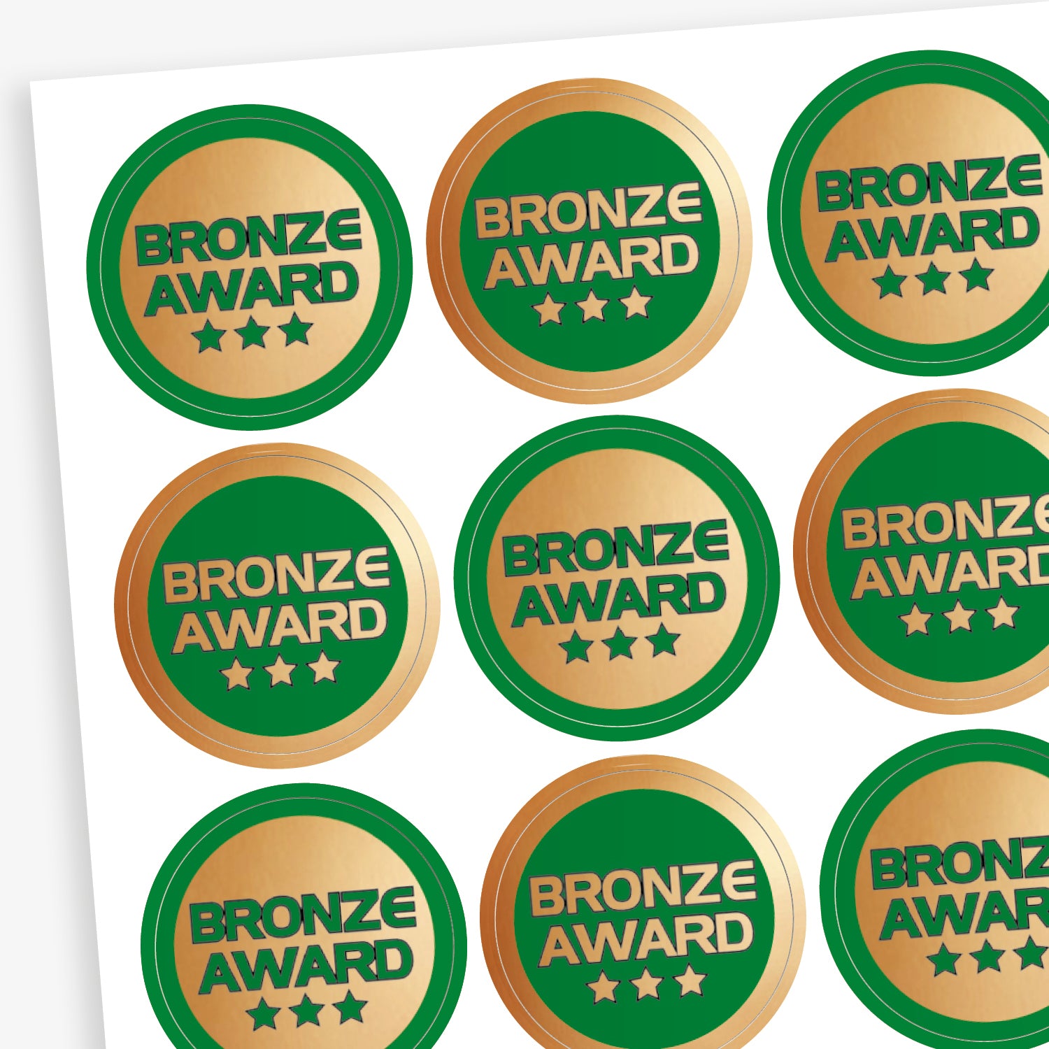 Sheet of 70, 25mm circular stickers with a metallic bronze finish; each sticker features the text 'BRONZE AWARD' above 3 stars.  The sheet has 50% stickers with a bronze base and green text, and 50% a green base with bronze text.