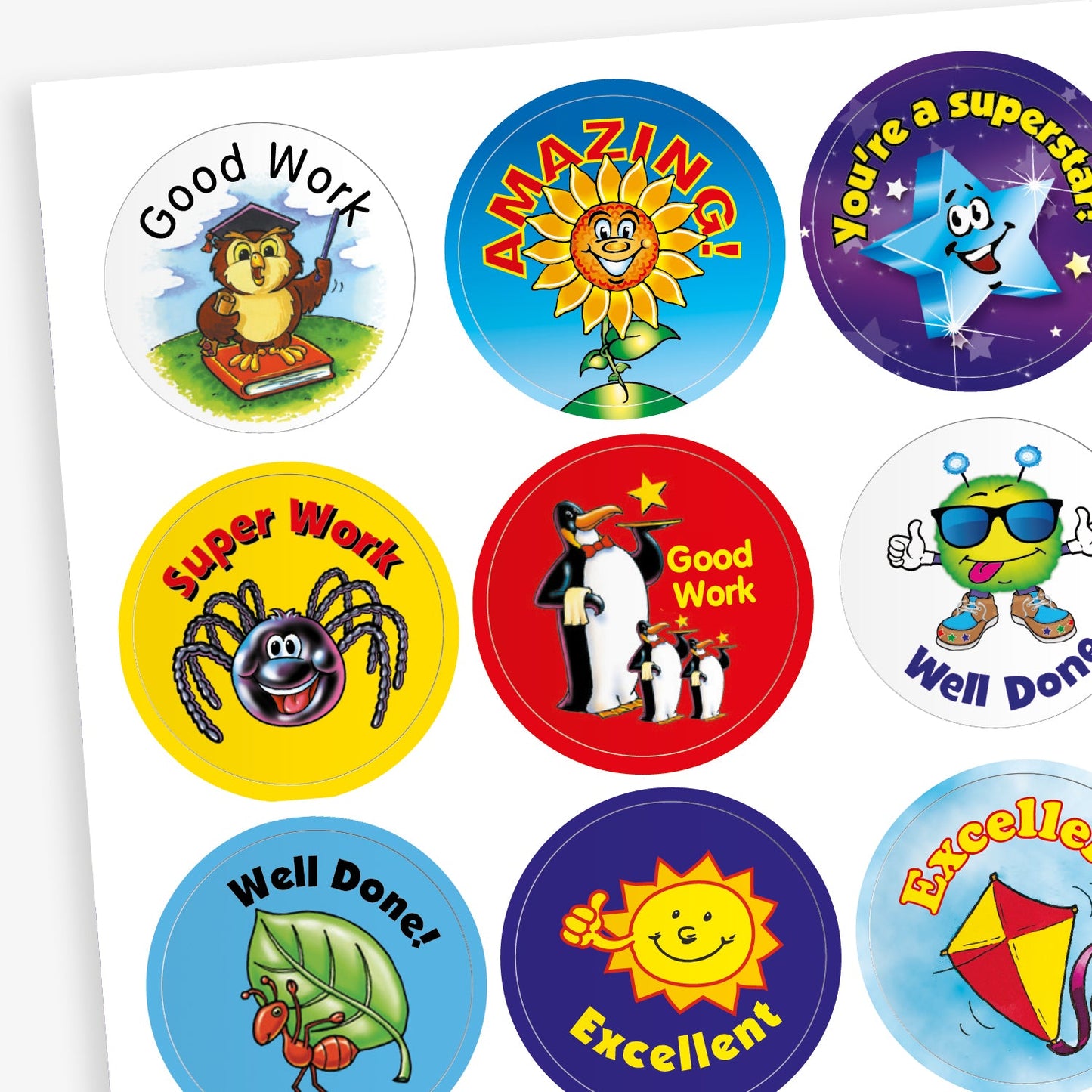 A sheet of colourful circular reward stickers featuring cheerful characters and motivational phrases such as 'Good Work', 'Amazing', 'You're a Superstar', 'Super Work', 'Well Done', and 'Excellent'. Designs include an owl, sunflower, spider, penguins, a robot with sunglasses, a ladybird, a smiling sun, and a kite, each set against vibrant backgrounds to encourage positive behaviour and achievement
