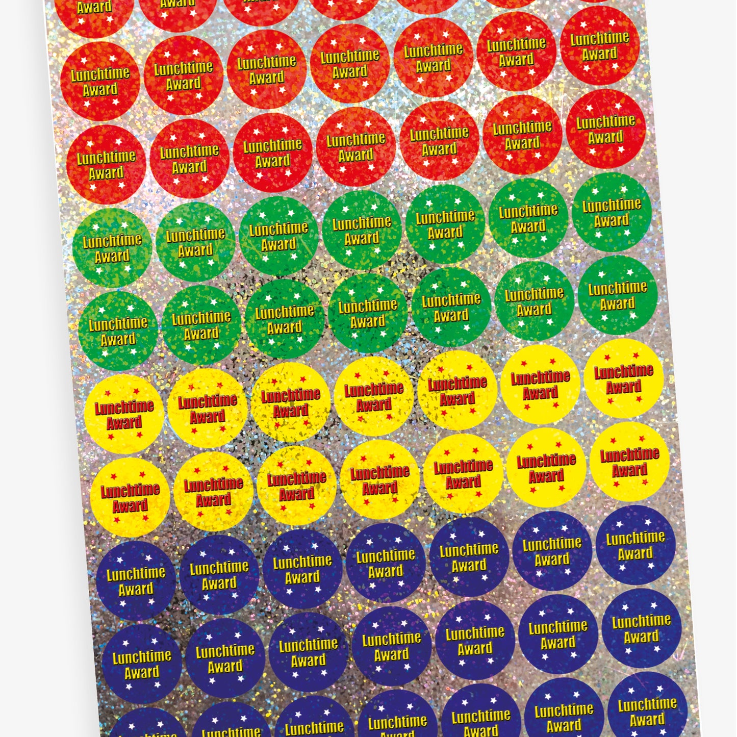 A sheet of 25mm round holographic 'Lunchtime Award' stickers. Each sticker features a vibrant, reflective background in colours such as red, blue, green, and yellow, with the text 'Lunchtime Award' in bold red or yellow letters. Ideal for recognising positive behaviour during lunchtime.