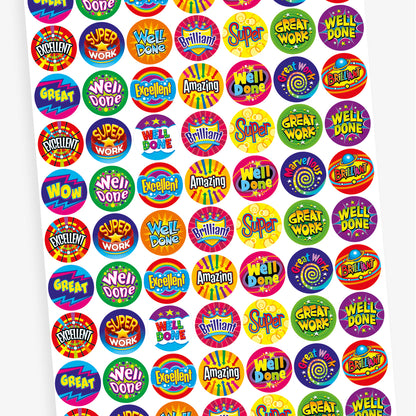 A sheet of vibrant circular reward stickers with motivational phrases such as 'Amazing', 'Great', 'Well Done', 'Excellent', 'Brilliant', and 'Great Work'. Each sticker features bold, colourful text with dynamic backgrounds in patterns like stars, bursts, and zigzags, designed to celebrate achievements and encourage positivity.
