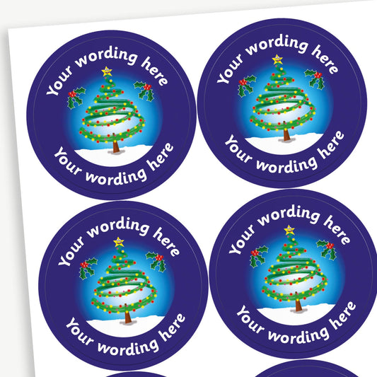 A sheet of customisable circular stickers featuring a dark blue border and a central image of a christmas tree outide in the snow.  Placeholder text 'Your Wording Here' arcs above and below the image.