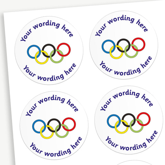 A sheet of white stickers featuring a olympic rings in the centre.  Placeholder text 'Your wording here' is above and below the image for customisation.