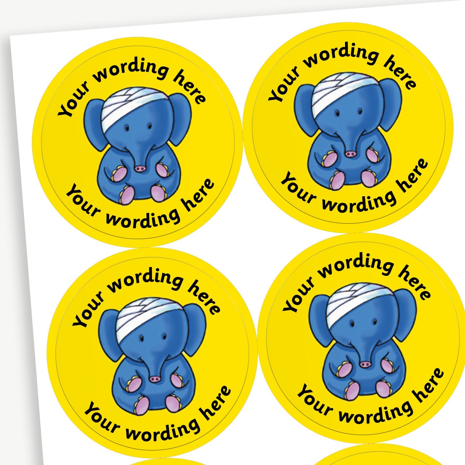 Sheet of round yellow stickers featuring an elephant with a bandage on it's head in the centre. Each sticker has placeholder text reading 'Your wording here' curved above and below the illustration. 
