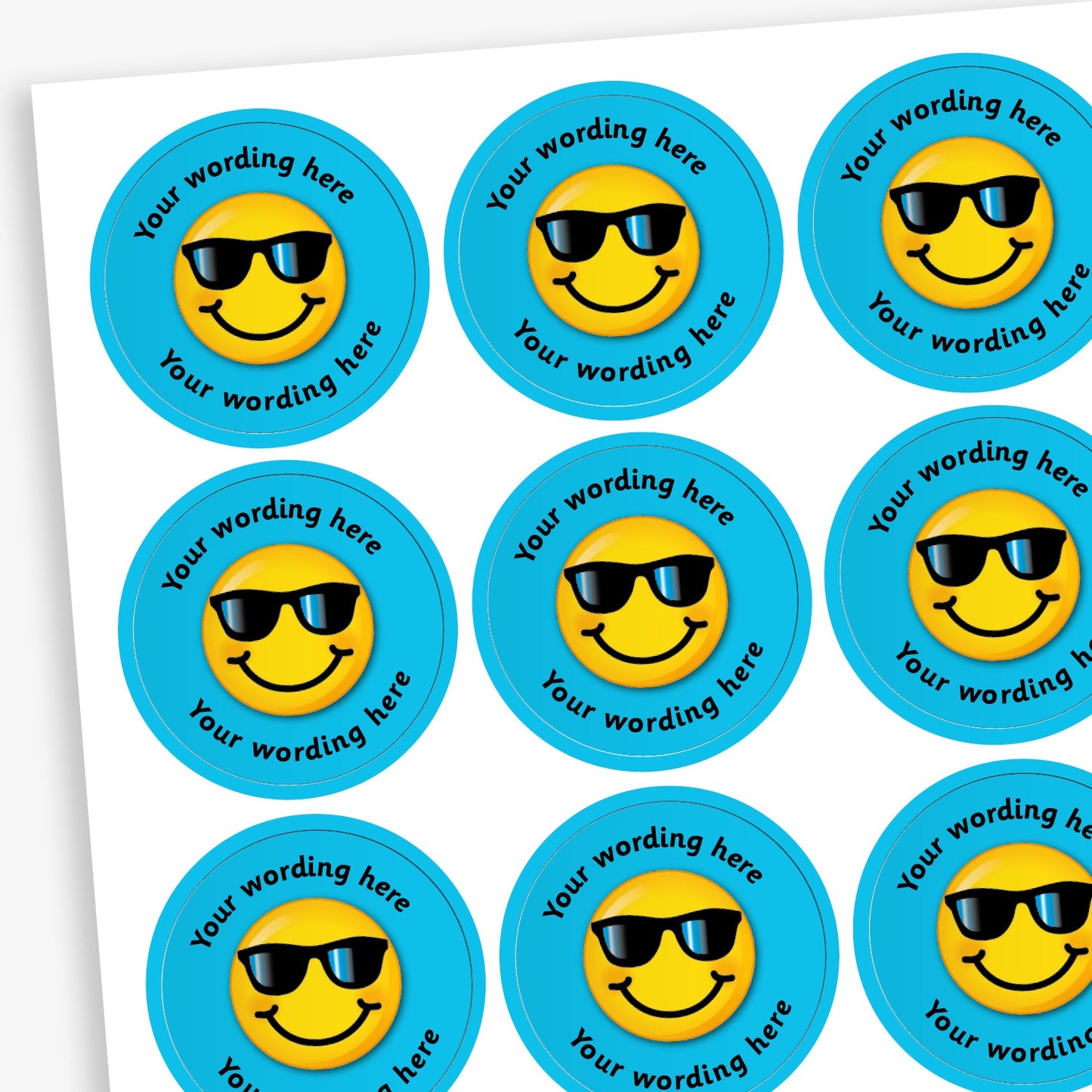 Sheet of round blue stickers featuring a smiling yellow face wearing sunglasses, with the phrase 'Your wording here' repeated around the top and bottom edges of each sticker.