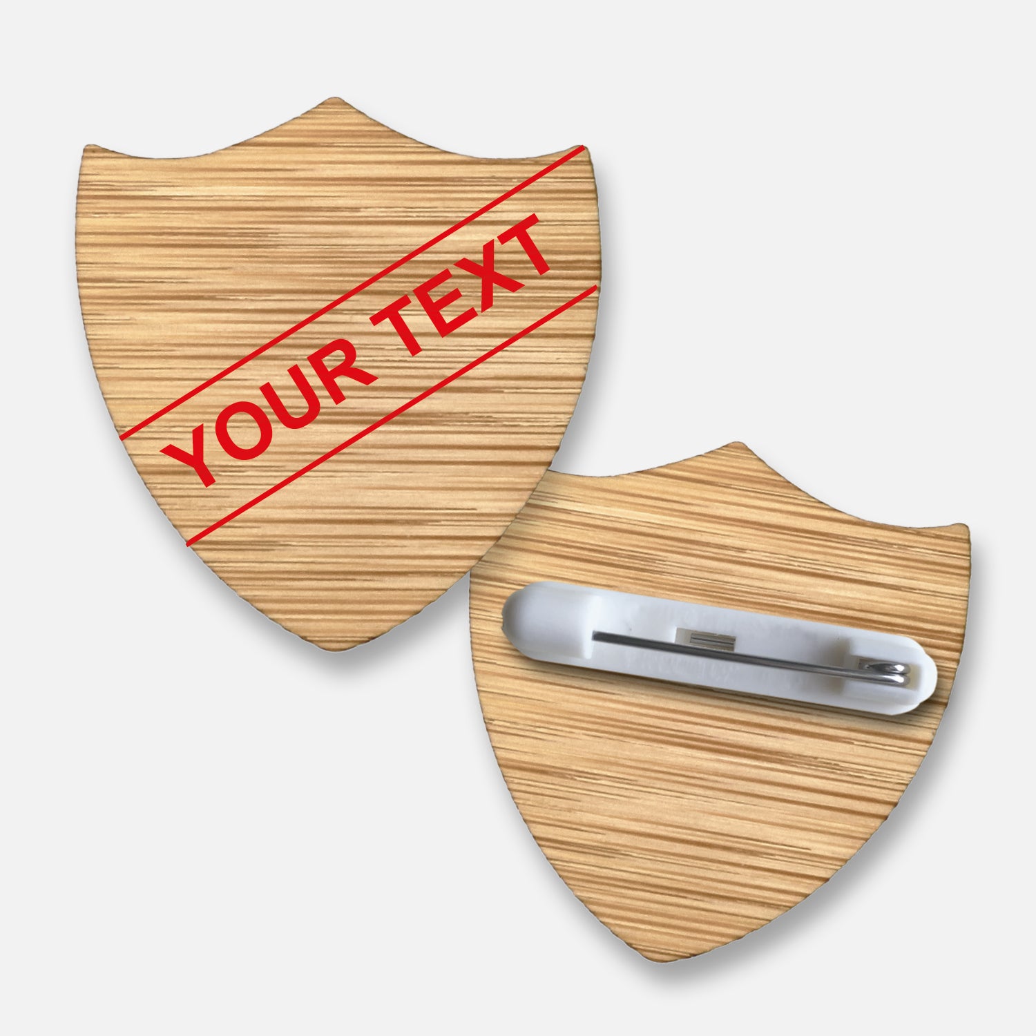 Personalised bamboo shield-shaped badge with natural wood grain finish.  Features a diagonal single line of customisable text in your choice of font and colour; measures approximately 34mm x 36mm and includes a pin fastening on the reverse.