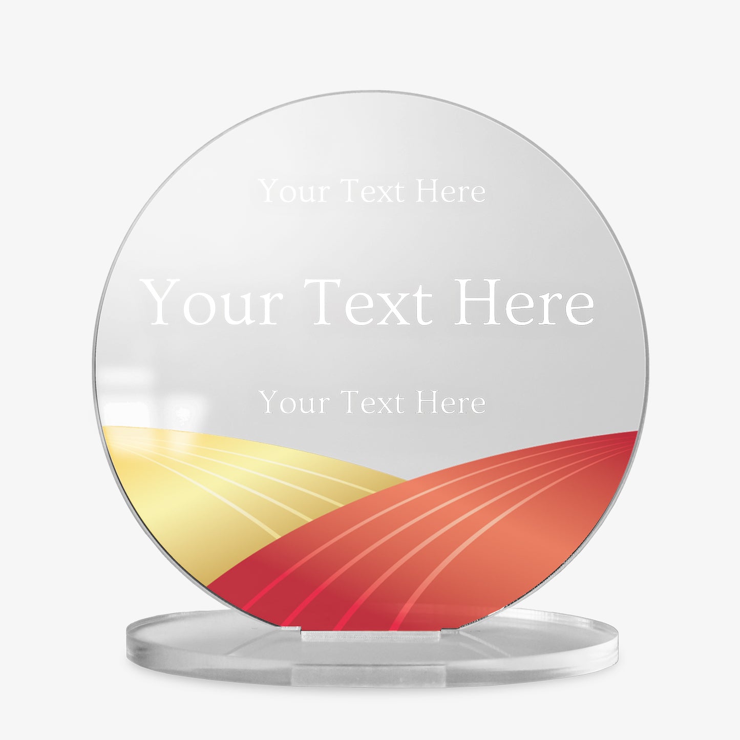 Round acrylic award plaque on a clear base, featuring a stylised gold and russet landscape graphic at the bottom and three lines of placeholder text for custom wording, displayed against a white background.