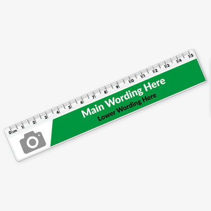 Customisable plastic ruler with a green and white design. It includes placeholder text reading 'Main Wording Here' and 'Lower Wording Here' in bold and regular fonts. A grey camera icon marks the area for a potential logo or image. The ruler is marked with centimetres and millimetres from 0 to 15.