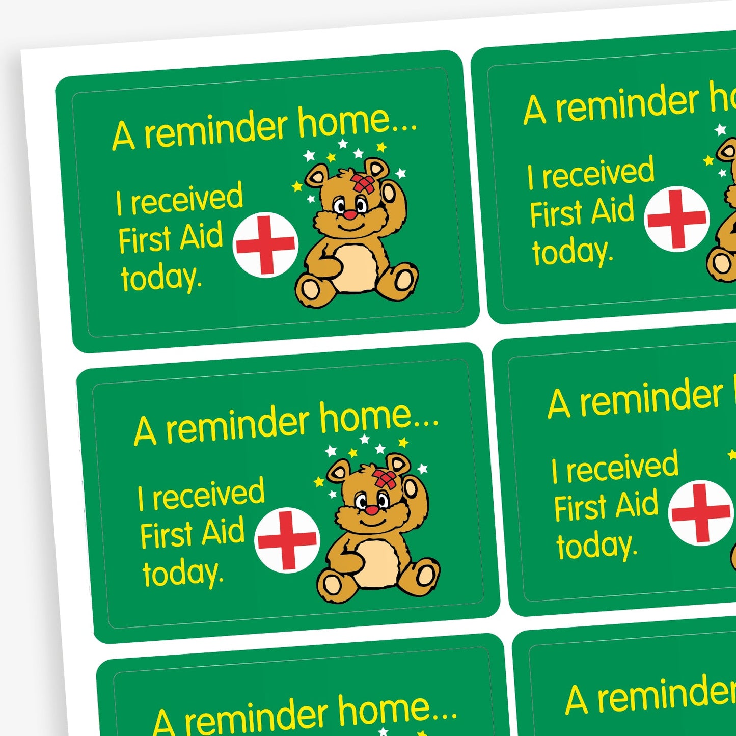 A sheet of green rectangular stickers with a message reading, 'A reminder home... I received First Aid today.' Each sticker includes a cartoon teddy bear with a bandage and stars above its head, and a red medical cross symbol, intended to inform parents or carers about minor first aid incidents at school.