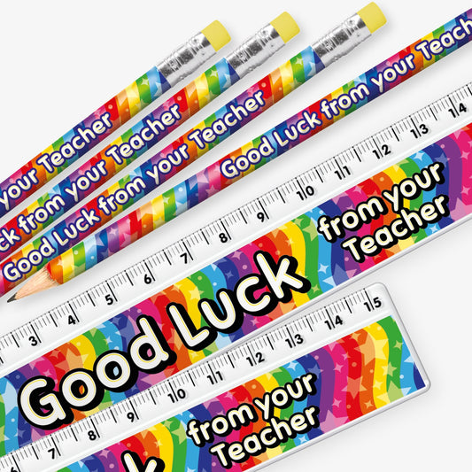 Set of 12 matching pencil and ruler pairs, each featuring a vibrant rainbow background with stars and bold yellow and white text reading 'Good Luck from your Teacher' along the side.