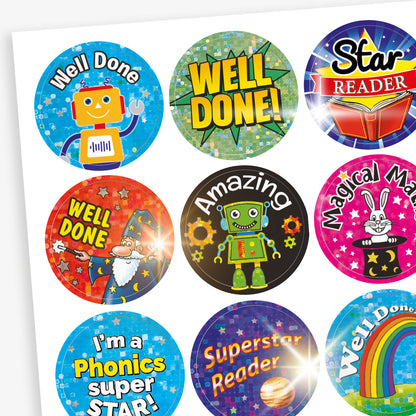 Sheet of colourful reward stickers featuring a variety of fun designs including robots, wizards, rainbows, books, and stars. Messages include 'Well Done', 'Amazing', 'Magical Maths', 'Star Reader', 'Superstar Reader', and 'I'm a Phonics Super Star'.