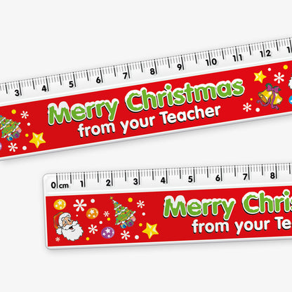 A close up of a red 15cm ruler featuring the phrase 'Merry Christmas' in bold green letters, and underneath in bold whote letters 'from your Teacher' decorated with colourful festive icons like Father Christmas, Christmas tree, present, bells and stars.
