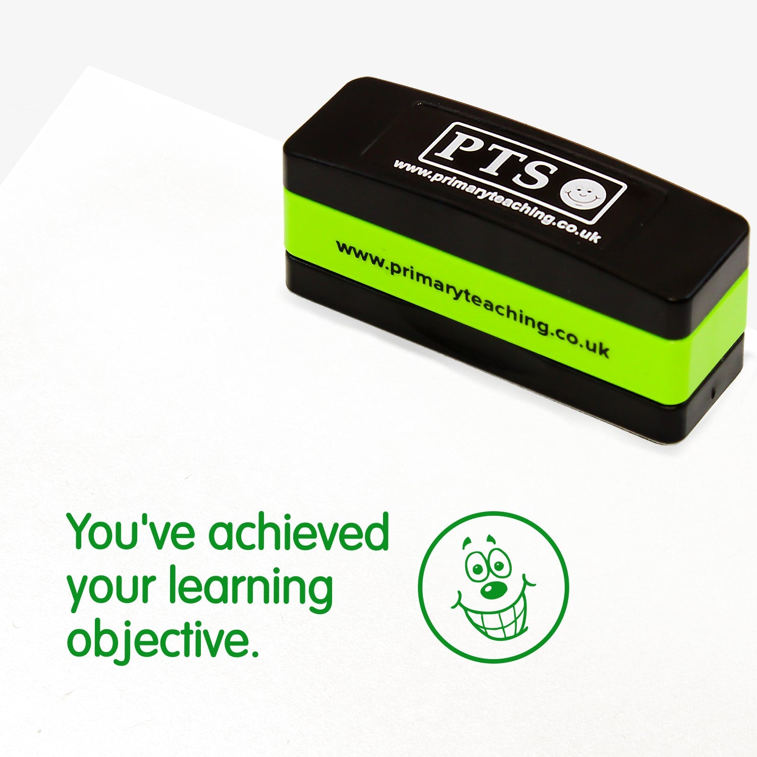 A rectangular, stackable, self-inking stamper, displaying the green text 'You've achieved your learning objective' alongside a smiling emoji face; stamper measures 44mm by 13mm