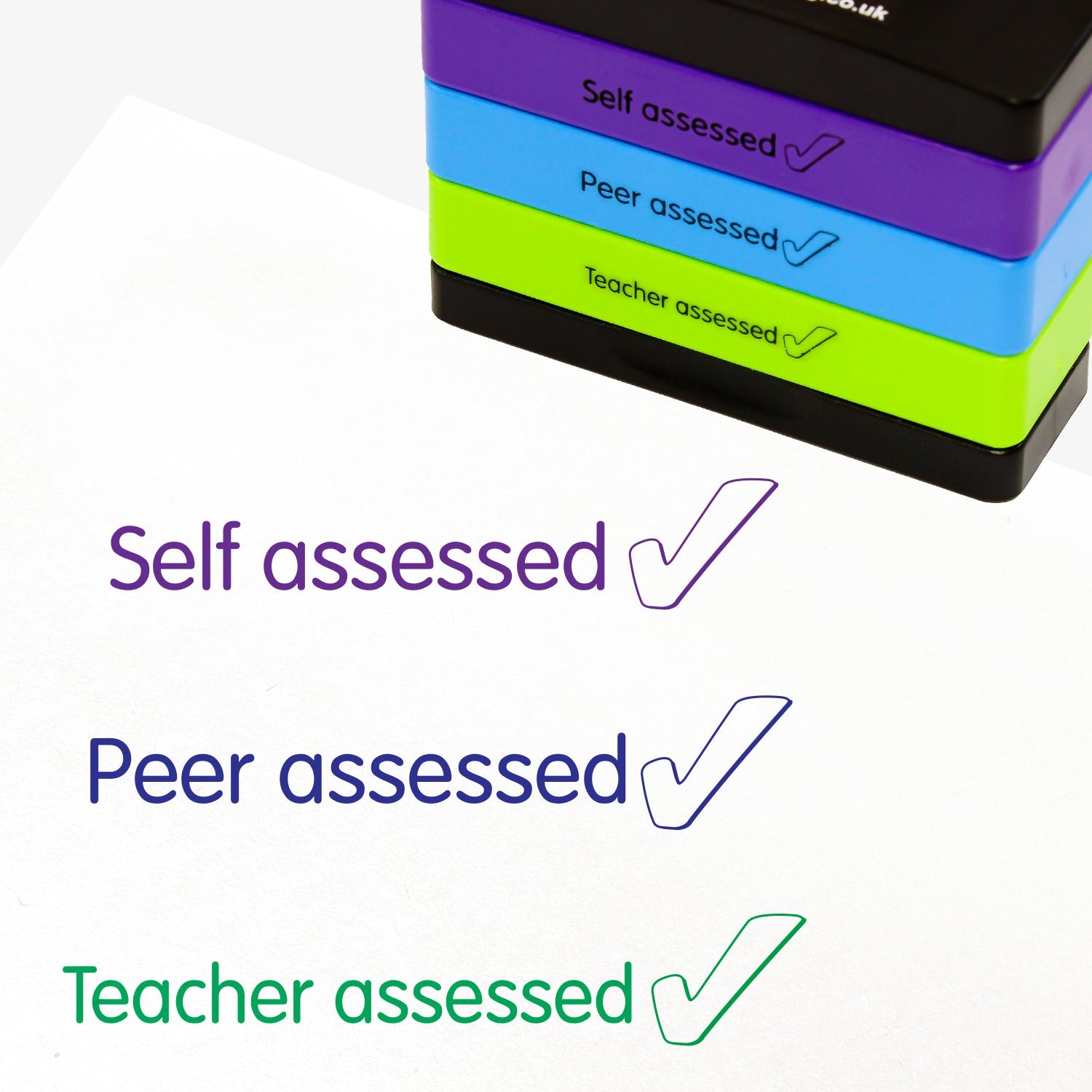 3 stacked rectangular self-inking stampers measuring 44mm by 13mm, featuring the imprint - 'Self Assessed' with a tick icon in purple ink; 'Peer assessed' with a tick icon in blue ink; 'Teacher assessed' with a tick icon in green ink.