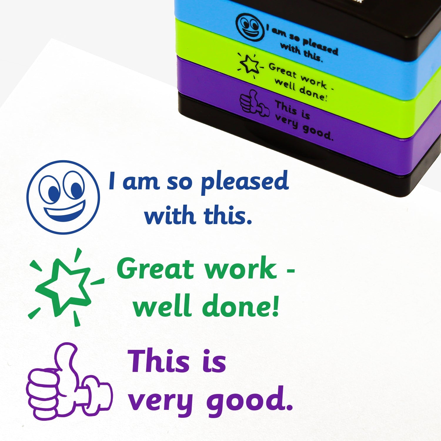 3 stacked rectangular self-inking stampers measuring 44mm by 13mm, featuring the imprint - 'I am so pleased with this' in blue ink with a blue smiling emoji to the left; 'Great work - well done!' in green ink with a shining green star to the left; 'This is very good.' in purple ink with a purple thumbs up icon.
