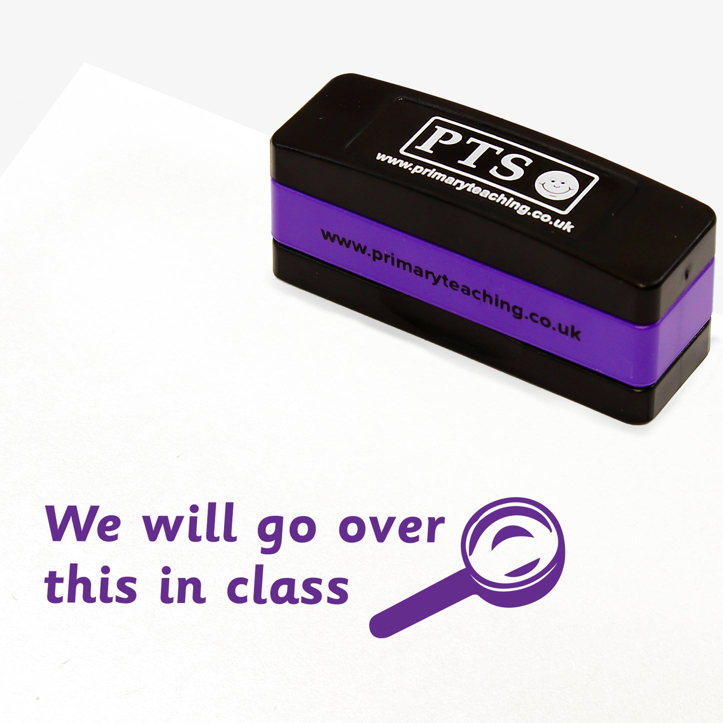 Rectangular self-inking stackable stamper 44mm x 13mm with purple ink, displaying the text 'We will go over this in class' alongside the purple outline of a magnifying glass.