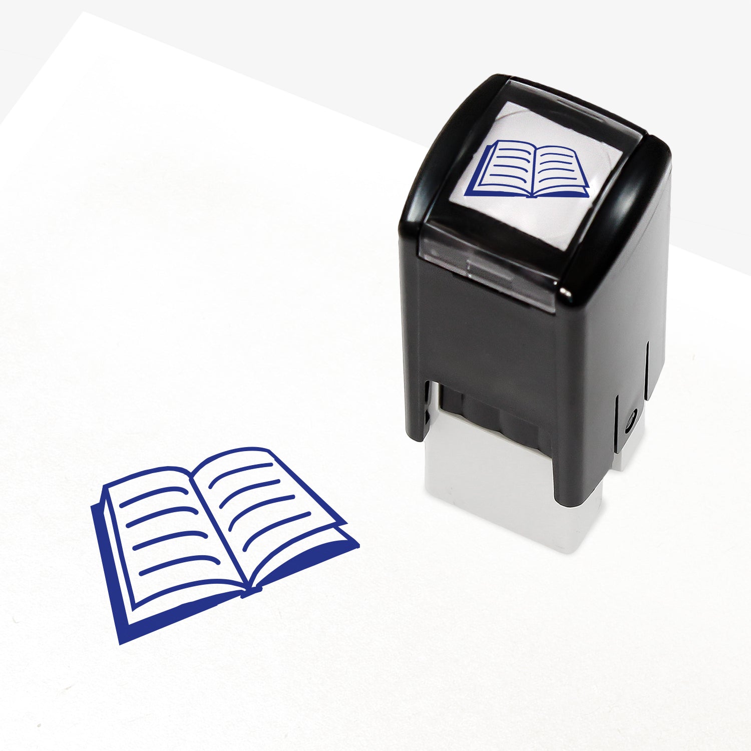 A 10mm self-inking stamp with a blue open book with lined pages central to the design