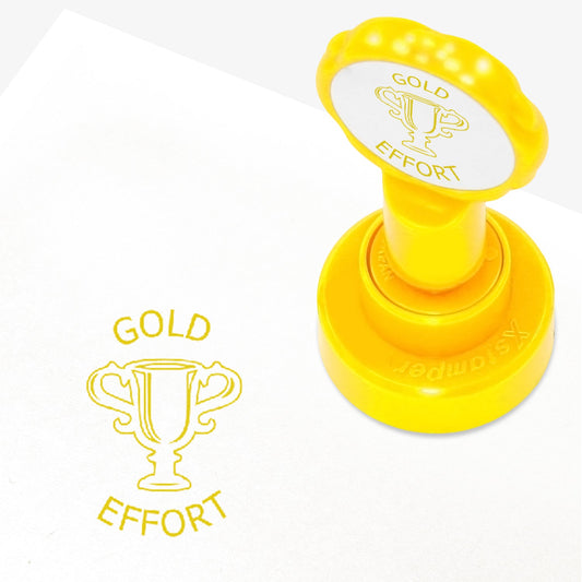 25mm self-inking stamper with gold ink.  The stamp impression is a central image of a gold trophy with the work 'GOLD' above and 'EFFORT' below.