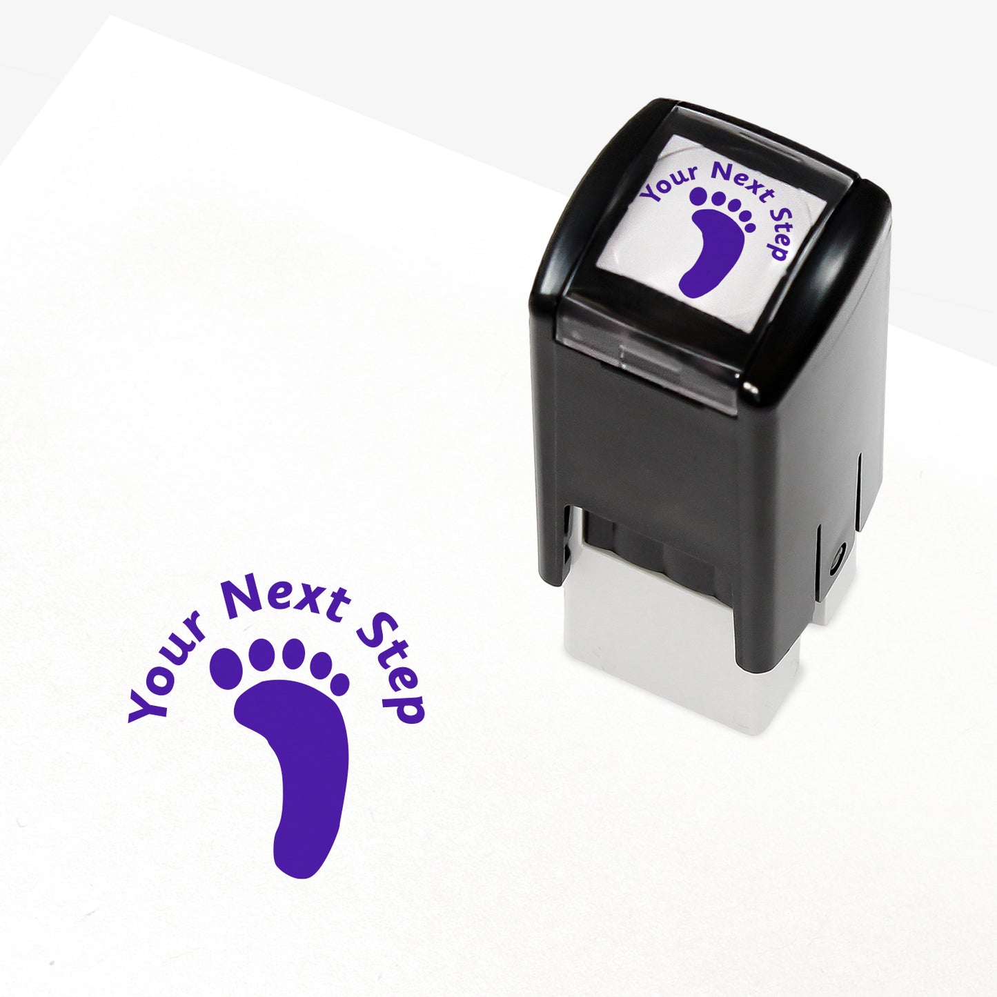 Purple 25mm pre-inked stamper featuring a footprint with the phrase 'Your Next Step' above.