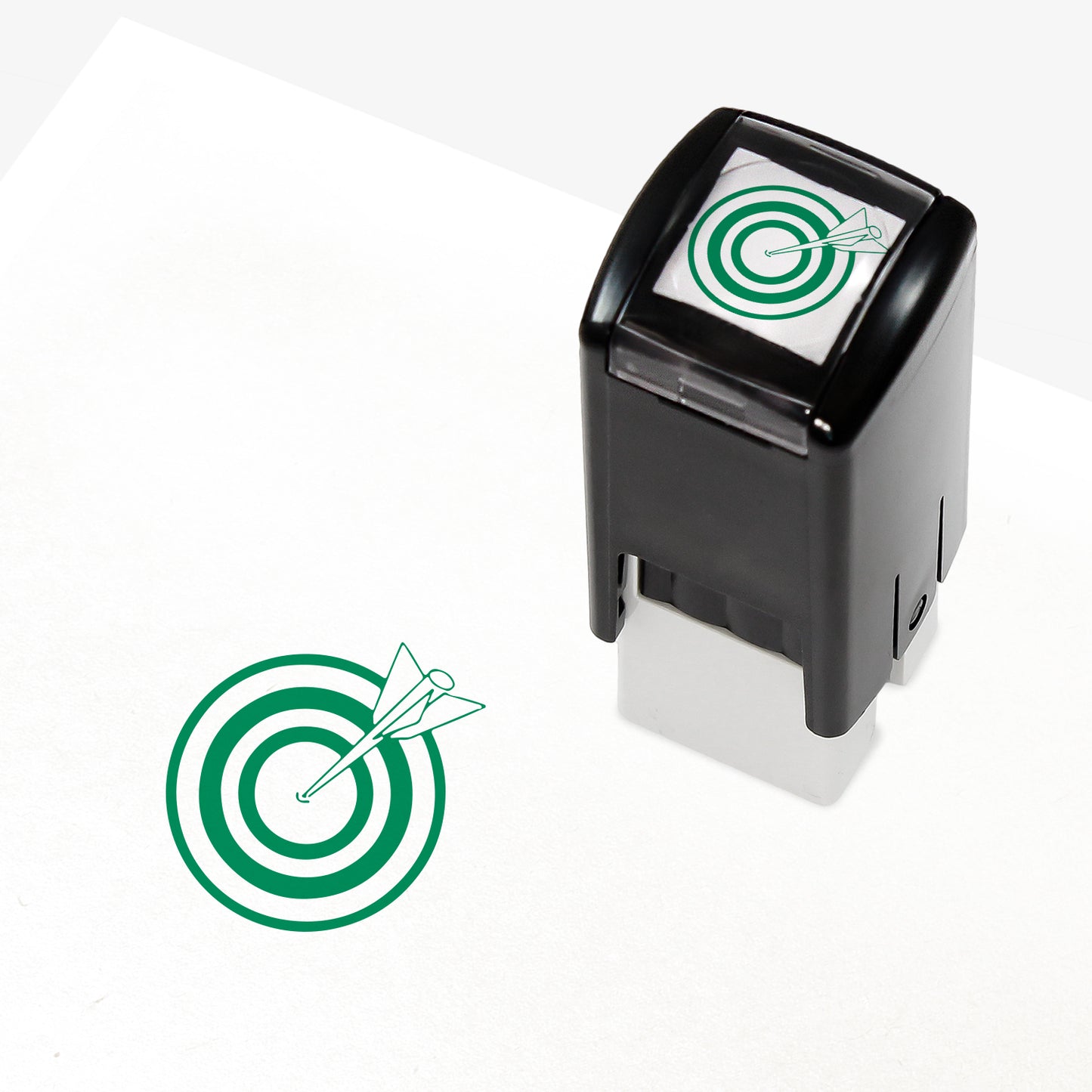 Target Stamper featuring a compact black casing with a green bullseye and arrow design. The stamp imprint measures 10mm in diameter and is available in various ink colours, ideal for marking pupil achievements.