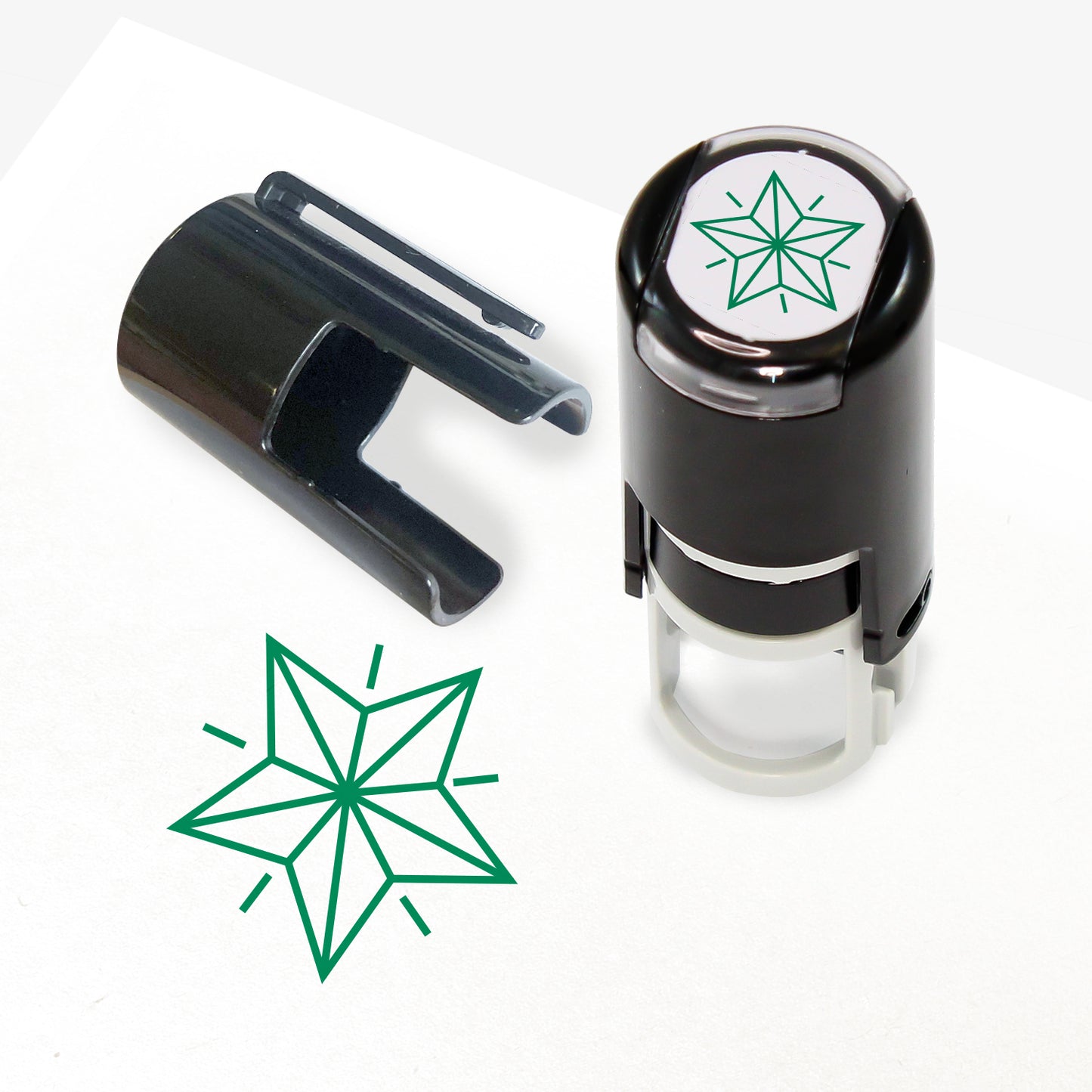 A 10mm self-inking stamp with a green outline 3D style star central to the design.  The stamper lid also shows a clip for attaching the stamper to a lanyard.