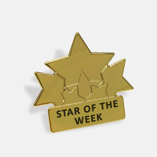 Gold-coloured enamel badge featuring three large stars, and three smaller stars above a rectangular plaque engraved with the words 'Star of the Week' in black text.